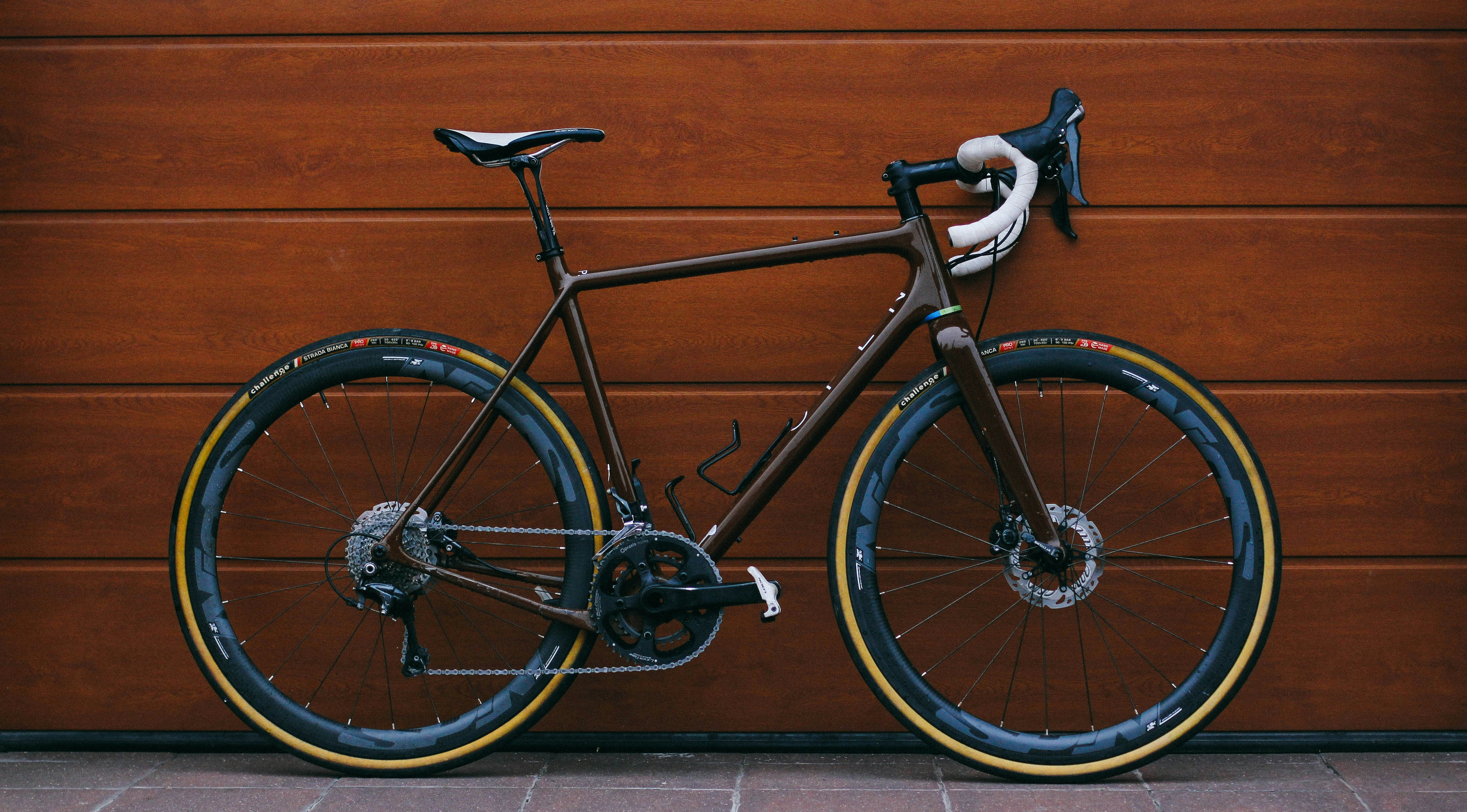 black road bike against wooden wall